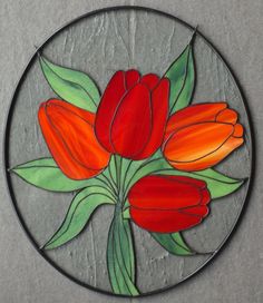 a stained glass piece with red flowers on it