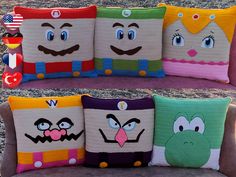 four pillows with faces on them sitting on a couch