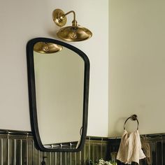 a bathroom sink sitting under a mirror next to a wall mounted faucet