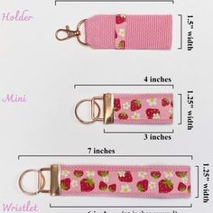 two pink key fobs with strawberries and flowers on them are shown in three different sizes