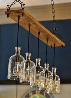 a wooden shelf with many bottles hanging from it's sides and some lights on them