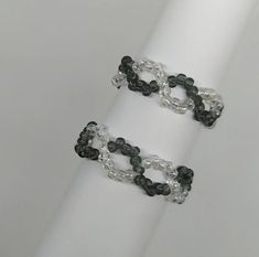 two bracelets with black and white beads are on a white napkin holder, one is made out of plastic