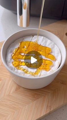 a white bowl filled with food on top of a wooden table