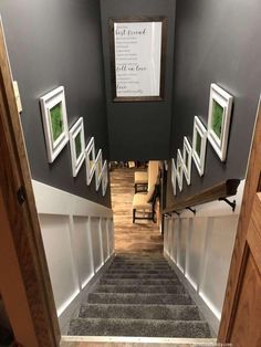 the stairs lead to an office building with pictures hanging on the wall and below them