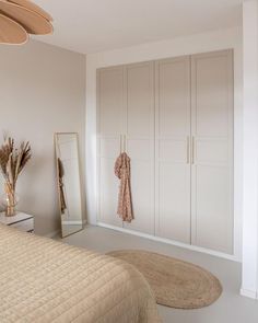 a bedroom with white walls and beige furniture