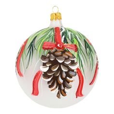 a glass ornament with pine cones and red ribbon on it's side