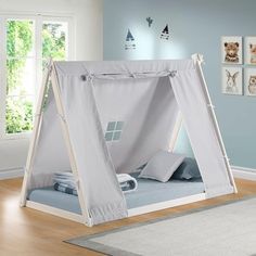 a bed with a tent on top of it in a room next to a window