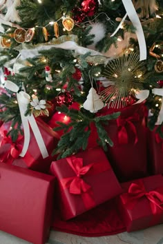 presents under the christmas tree are wrapped in red and white ribbons with bows on them