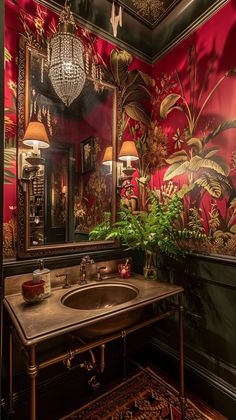 a bathroom decorated in red and gold with green plants on the wall, mirror above sink