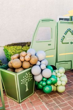 there is a truck with balloons in the trunk and on the ground next to it