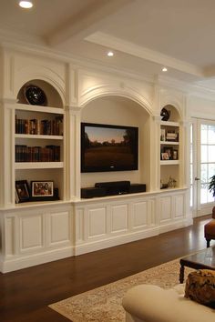 a living room filled with furniture and a flat screen tv on top of a wall