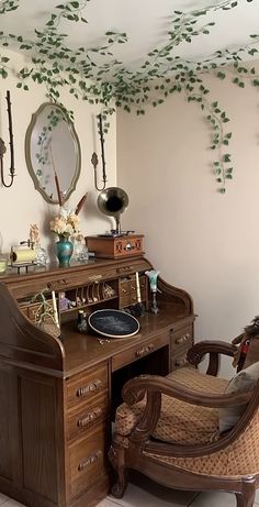 an old fashioned desk and chair in a room with ivy growing on the wall above it