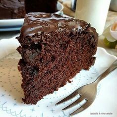 a piece of chocolate cake sitting on top of a white plate next to a fork