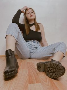 a woman is sitting on the floor with her feet up in front of her head