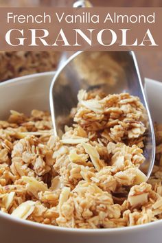 a white bowl filled with granola sitting on top of a table next to a spoon