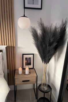 there is a vase with some feathers on it next to a mirror and a table