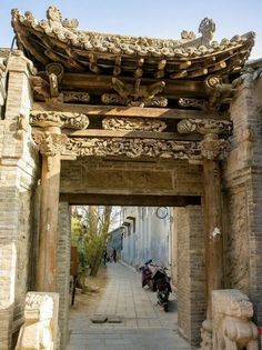 an archway leading to a building with statues on either side