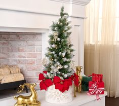 a decorated christmas tree sitting on top of a white mantle next to a fire place