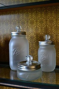 two glass jars sitting on top of a shelf