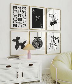 a living room with white furniture and art on the wall