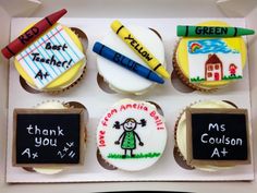 four decorated cupcakes in a box with chalk markers and writing on the frosting