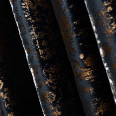 an old black and gold curtain with rusted metal foil on the outside, in close up