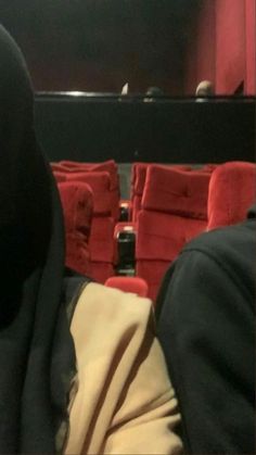 two people sitting in front of red chairs