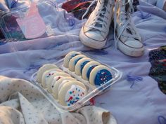 there are many decorated cookies in the tray on the table next to each other,