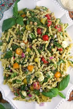 pasta salad with spinach and tomatoes on a white plate