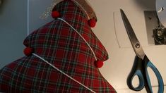 a pair of scissors sitting on top of a counter next to a red and white pillow