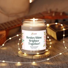 a candle sitting on top of a table next to a string of lights and a guitar