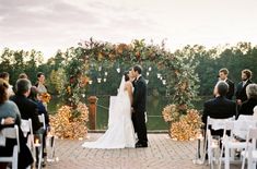 a bride and groom kissing in front of an outdoor ceremony