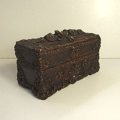 an old wooden box sitting on top of a white table