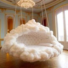 a bed made out of foam is suspended in the middle of a room with chandelier