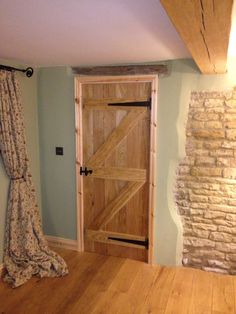 a wooden door is open in a room with blue walls and wood flooring, along with a stone fireplace