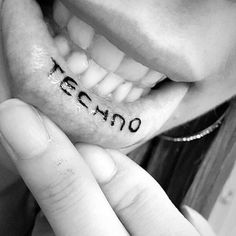 a woman holding up her teeth with the word te amo written on it