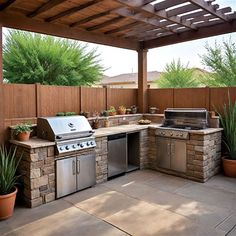 an outdoor kitchen with grill, sink and potted plants