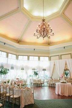 a banquet hall with tables and chandeliers