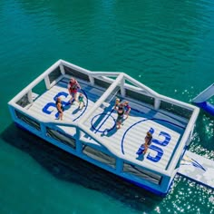 two people on a boat in the water with numbers painted on it's sides