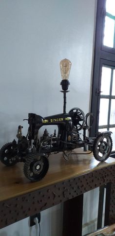 an old fashioned sewing machine sitting on top of a wooden table