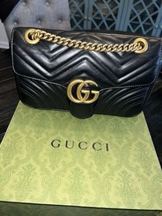 Elevate your style with this authentic Gucci Marmont Matelasse shoulder bag. Crafted in Italy from high-quality leather and antique gold-tone hardware, this bag features a push lock closure and double handles with a strap drop of 23". The bag is lined with microsuede and has a water-resistant finish, making it perfect for travel, weddings, parties, and more. It also has multiple pockets, including a mobile phone pocket, and is small enough to carry essentials while on-the-go. The bag is part of the Gucci Marmont product line and has a classic and preppy style that is perfect for any occasion. The black leather crossbody bag with gold hardware and stitching accents is a luxury item that is both stylish and functional. The bag is perfect for those who want to show off their love for Gucci an Gucci Marmont Matelasse, Gucci Gg Marmont Matelasse, Gucci Marmont, Flap Shoulder Bag, Gucci Gg Marmont, Black Leather Crossbody Bag, Gg Marmont, Luxury Items, Preppy Style