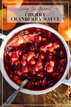 a white bowl filled with cranberry sauce on top of a wooden table next to oranges