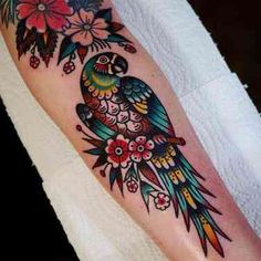 a colorful bird with flowers on its body and wings is sitting on someone's leg