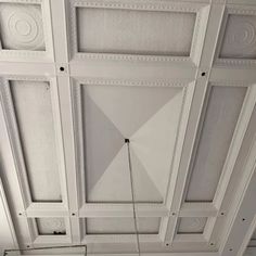 the ceiling is painted white and has geometric designs on it