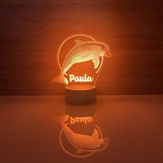 a lamp with a dolphin on it sitting on a table next to a wooden wall