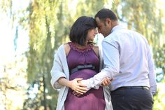 a pregnant woman and man standing next to each other