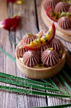 two small desserts on wooden boards with green leaves around them and flowers in the background