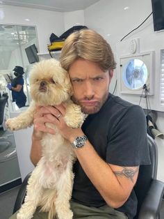 a man sitting in a chair holding a dog