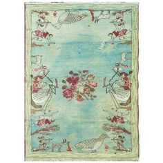 a blue rug with birds and flowers on the bottom, in front of a white background