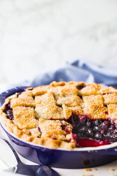 a blueberry pie in a bowl with a slice taken out of it's crust